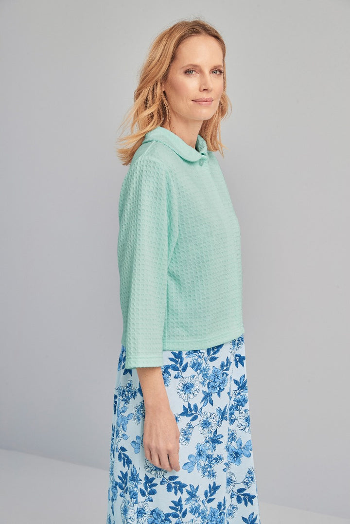 Lily Ella Collection mint green textured blouse paired with floral blue and white A-line skirt, elegant women's spring fashion outfit