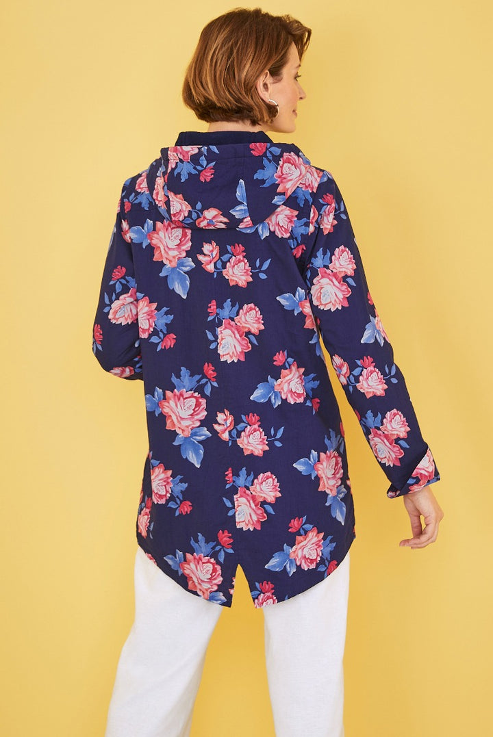 Lily Ella Collection women's navy blue floral print parka rear view with butterfly details on a yellow background, paired with white trousers.