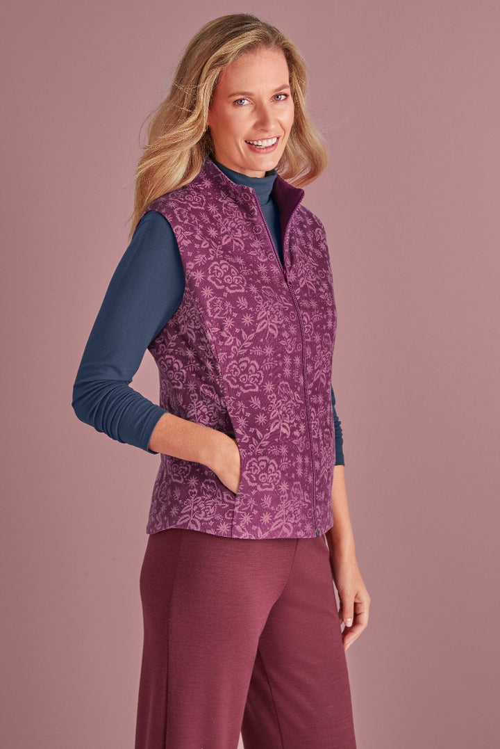 Lily Ella Collection purple floral patterned quilted gilet on model paired with navy long sleeve top and maroon trousers, stylish women's autumn outerwear.