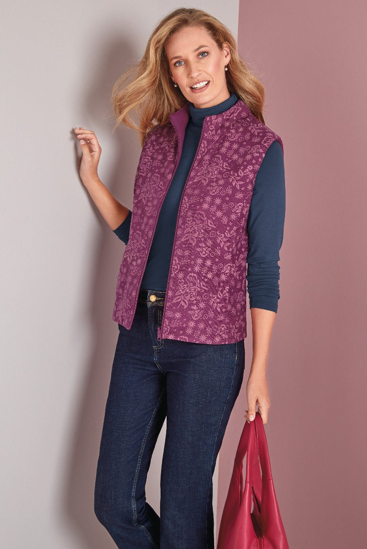 Lily Ella Collection purple paisley print gilet paired with navy turtleneck and jeans, model carrying red leather bag, stylish women's autumn fashion.
