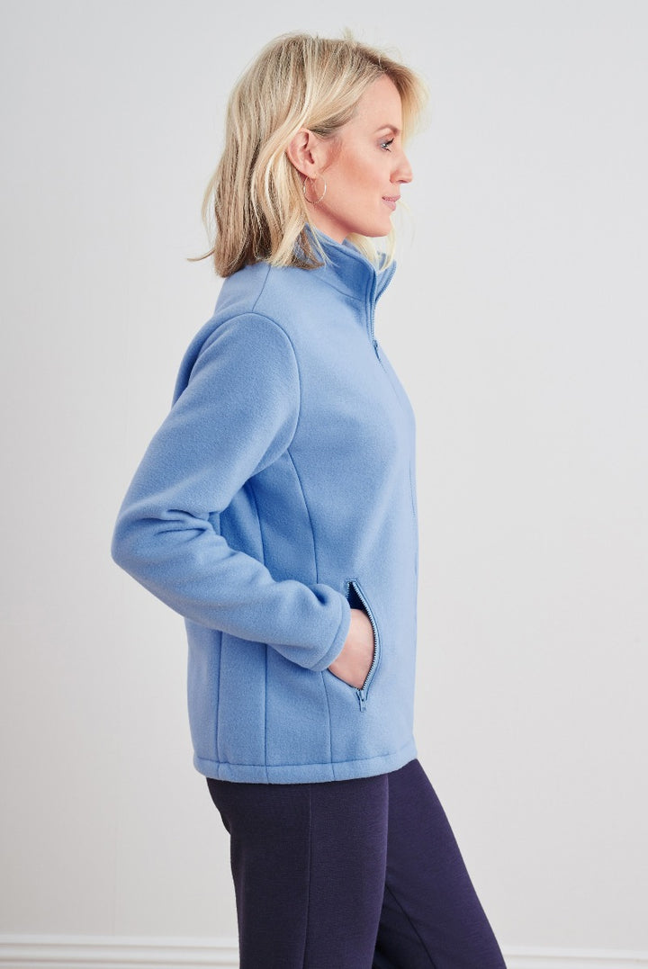 Lily Ella Collection periwinkle blue zip-up fleece jacket, side profile of a blonde model, casual and comfortable style with side pockets, paired with dark trousers for a cozy and chic look