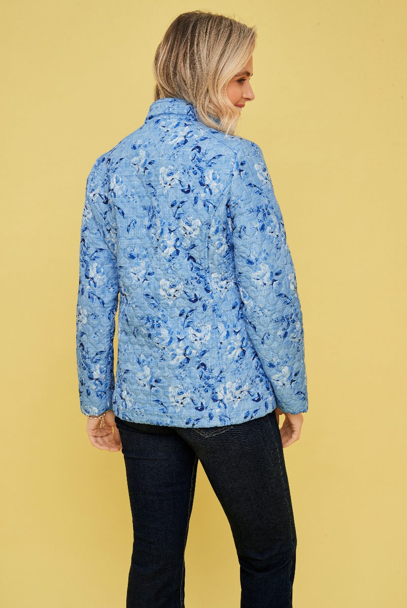 Lily Ella Collection floral blue jacket for women, stylish rear view of model wearing chic textured outerwear against a yellow background.