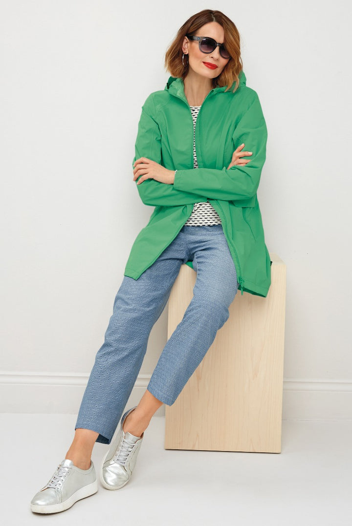 Lily Ella Collection chic green jacket, casual style, paired with blue denim jeans and metallic sneakers, woman posing with sunglasses.