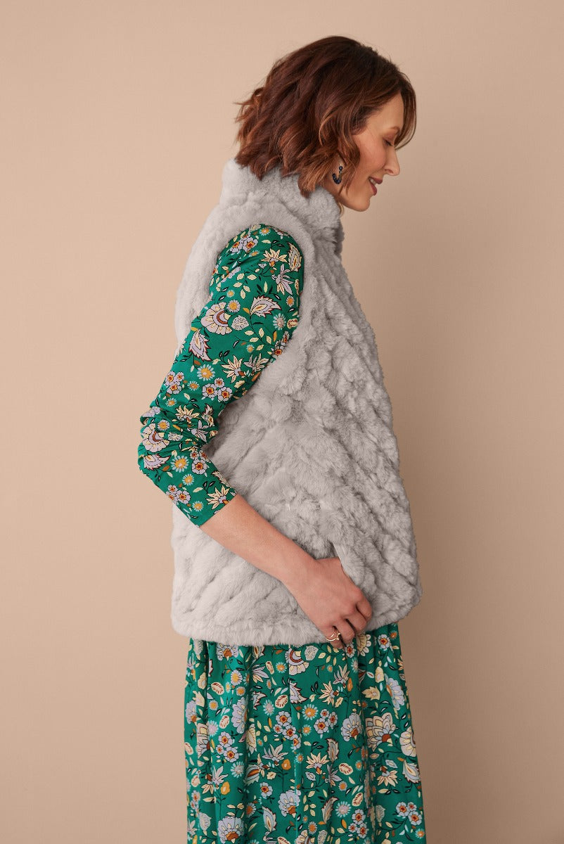 Lily Ella Collection elegant grey faux fur vest paired with floral print green dress, stylish women's autumn-winter fashion.