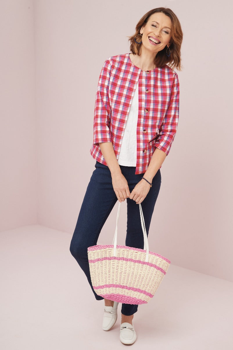 Lily Ella Collection casual chic red and white checkered blouse paired with navy jeans, white top, and complementary straw tote bag for a perfect spring outfit