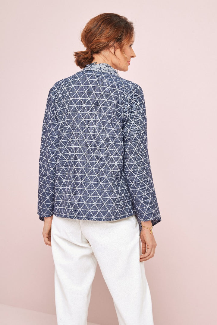 Lily Ella Collection stylish blue geometric-print blouse paired with elegant white trousers, showcasing modern women's fashion and sophisticated casual wear.