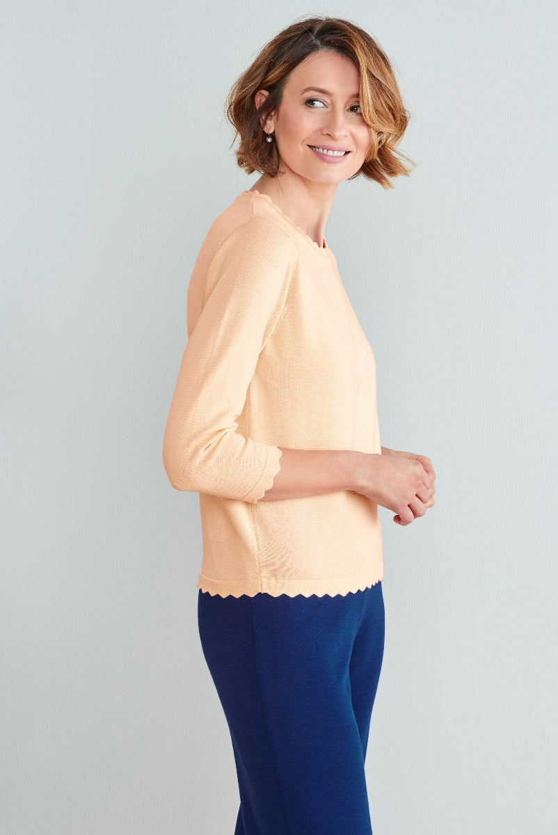 Lily Ella Collection peach scalloped hem jumper paired with navy trousers, stylish casual women's wear, elegant and comfortable fashion for mature women
