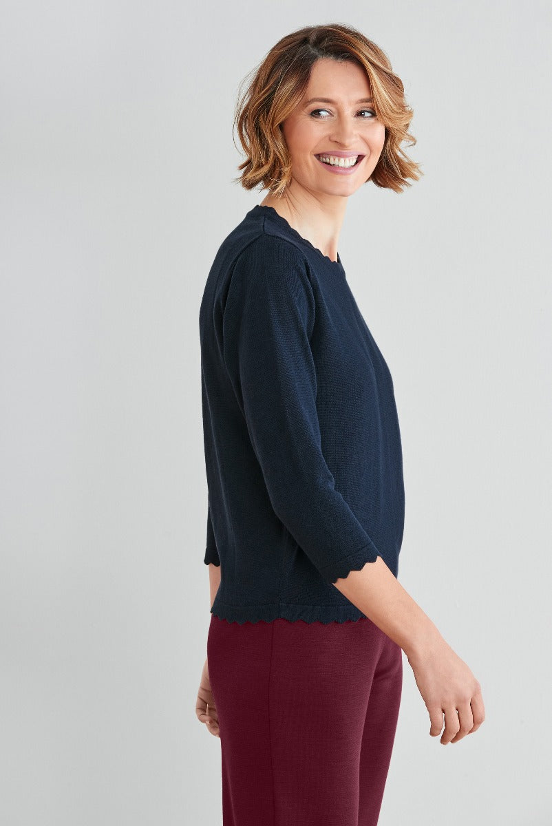 Lily Ella Collection navy blue gathered sleeve blouse with scalloped hem, stylish women's top, paired with maroon trousers, casual elegant clothing, fashion model showcasing outfit.