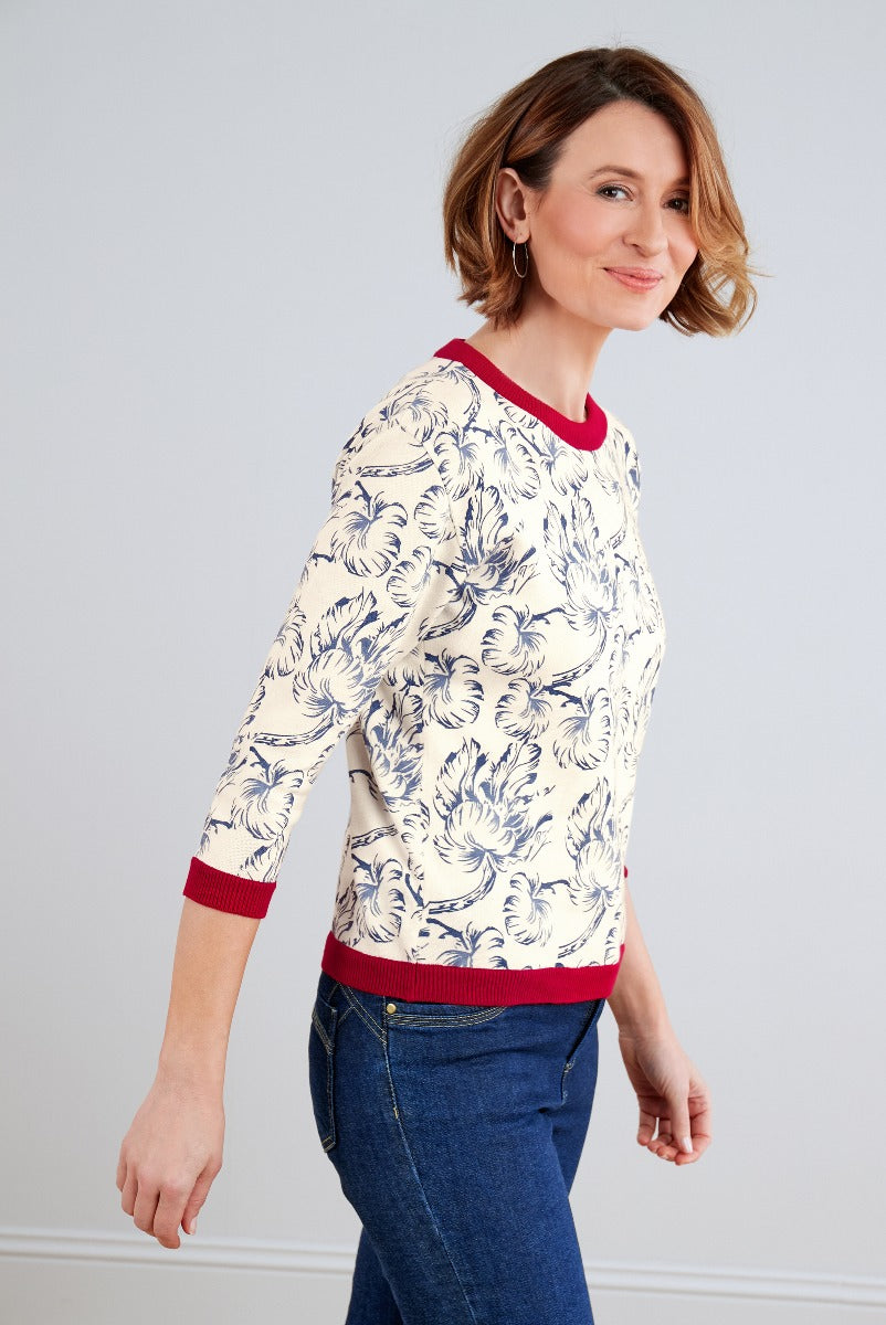 Lily Ella Collection ivory floral print sweater with red trim, casual elegant style, women's fashion clothing, side pose model wearing denim jeans