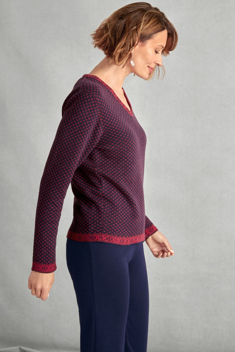 Lily Ella Collection women's stylish burgundy patterned jumper with red detailing and comfortable navy trousers, elegant casual wear, profile view.