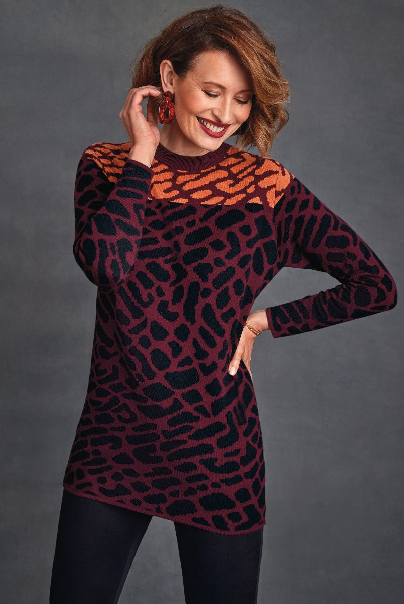 Lily Ella Collection stylish maroon and black animal print sweater, fashionable long sleeve knitwear for women, elegant casual top paired with black trousers and statement earrings.