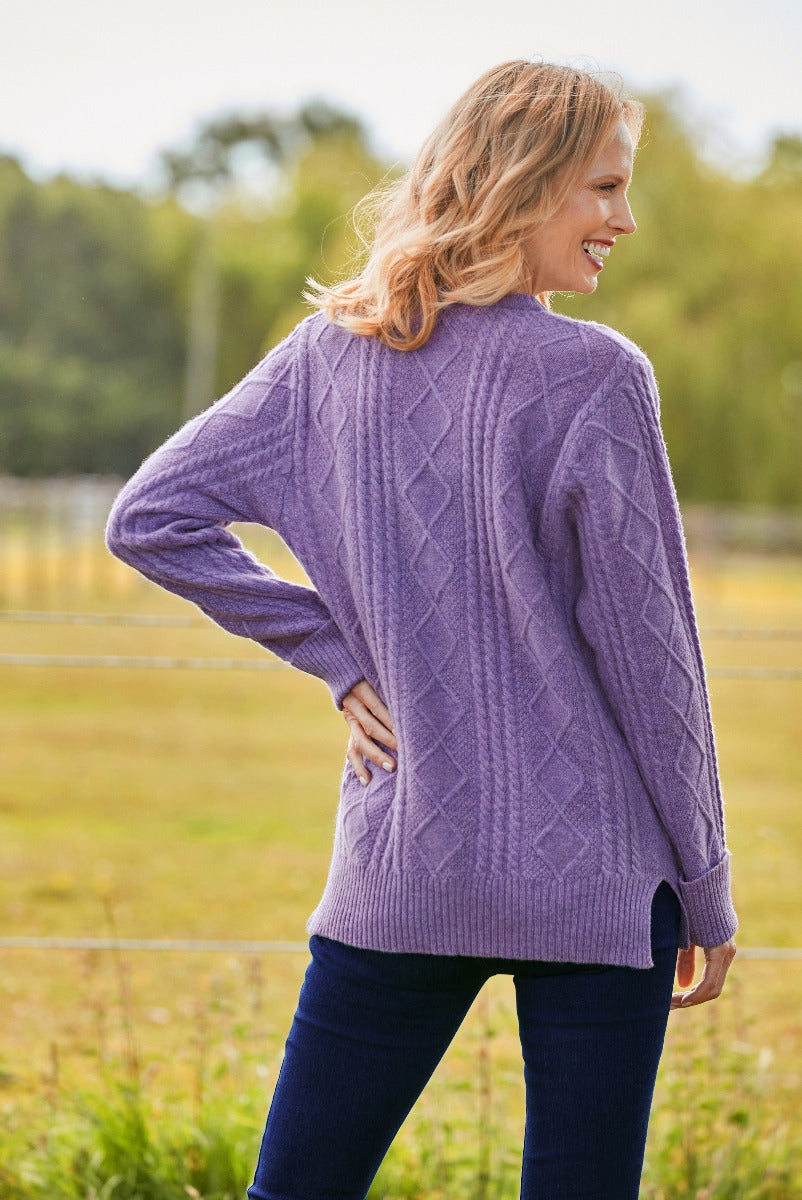 Lily Ella Collection purple cable knit jumper, women's stylish lavender sweater, comfortable casual autumn-winter fashion, paired with dark blue jeans.