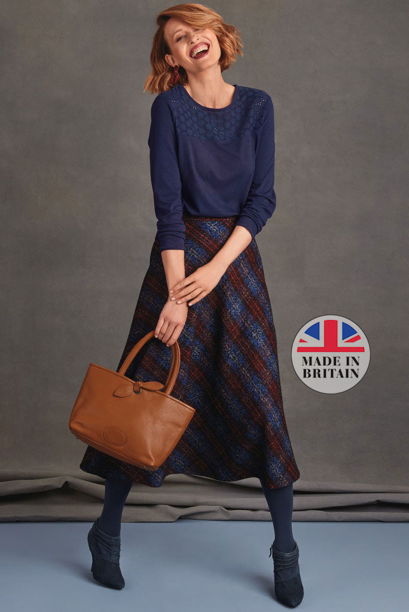 Lily Ella Collection stylish navy blue blouse with lace detailing, elegant multicolor midi skirt, and coordinating navy ankle boots, complemented by a tan leather tote bag, Made in Britain fashion.