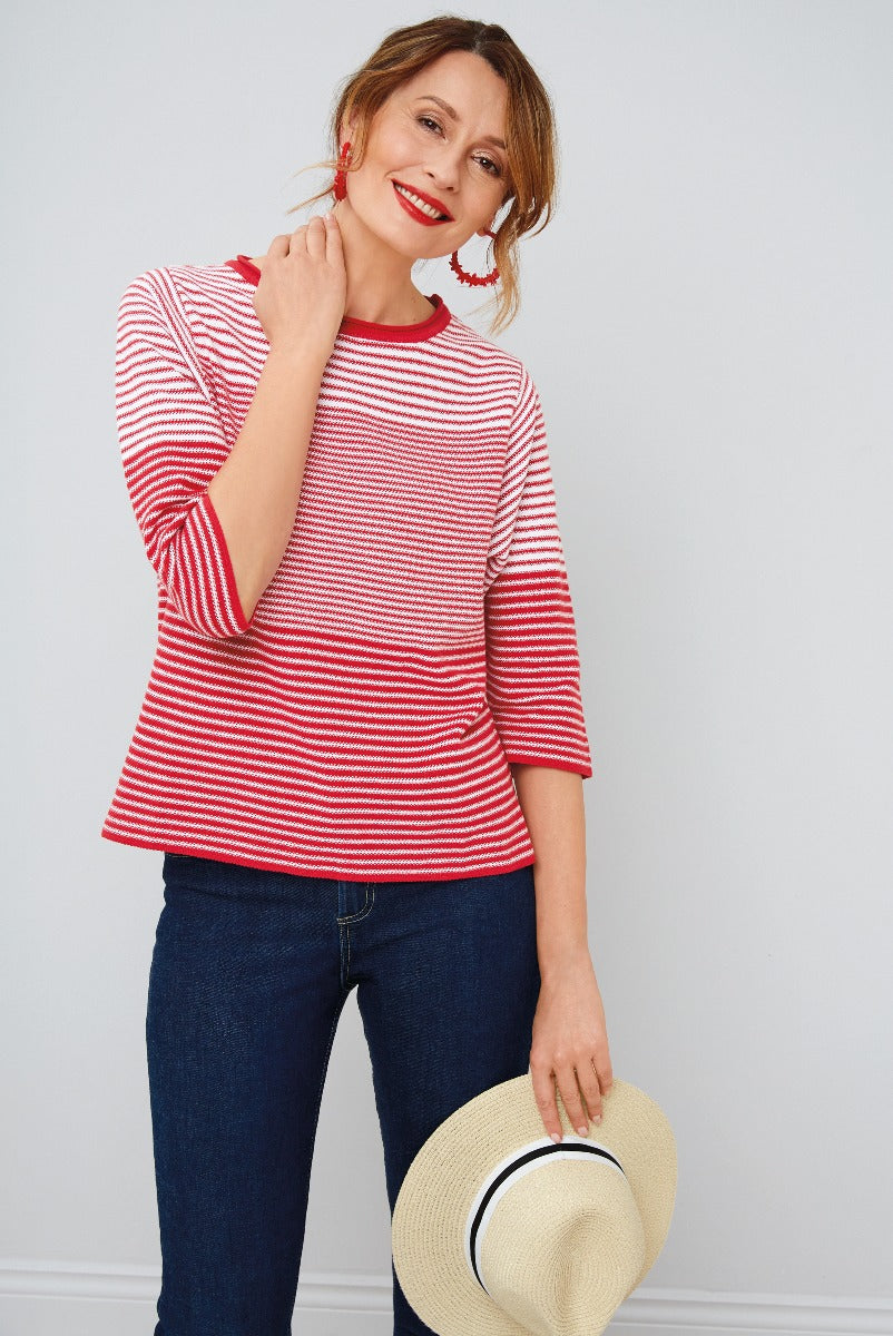 Lily Ella Collection women's casual style, red and white striped three-quarter sleeve top paired with dark blue jeans, complemented by red tassel earrings and holding a straw hat with ribbon detail.