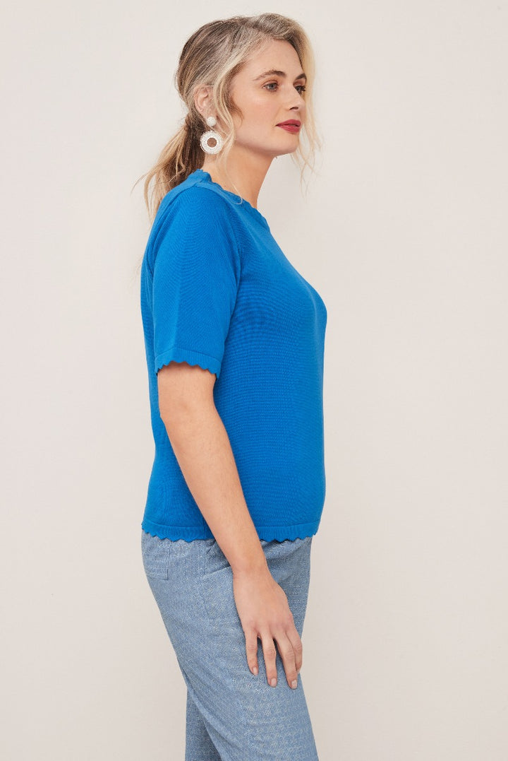 Lily Ella Collection vibrant cobalt blue scallop-edged knit top paired with casual denim, elegant white earrings, presenting a chic and comfortable look for women's fashion.