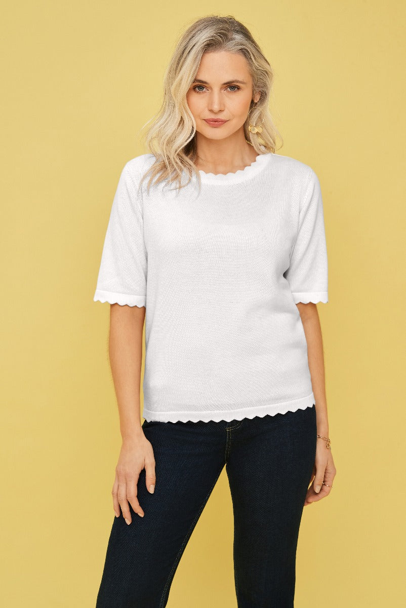 Lily Ella Collection white scalloped edge top elegant casual wear for women with denim jeans on yellow background