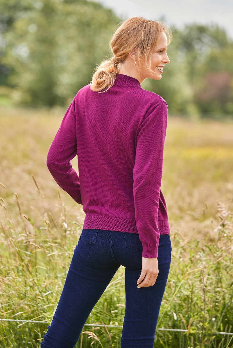 Lily Ella Collection fuchsia textured knit sweater with ribbed trim, paired with dark blue jeans for a casual chic look, outdoor fashion setting.