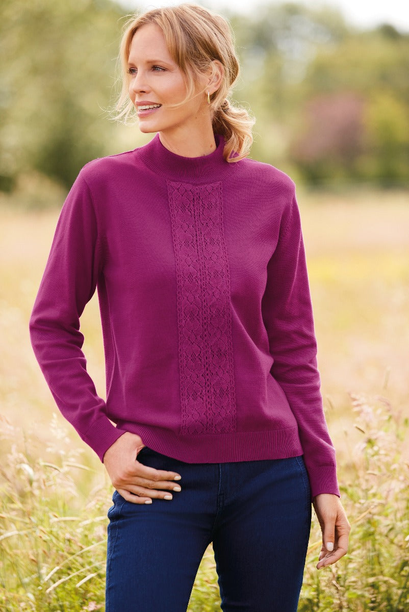 Lily Ella Collection elegant fuchsia cable knit jumper for women with a subtle pattern, paired with navy trousers, outdoor natural setting.