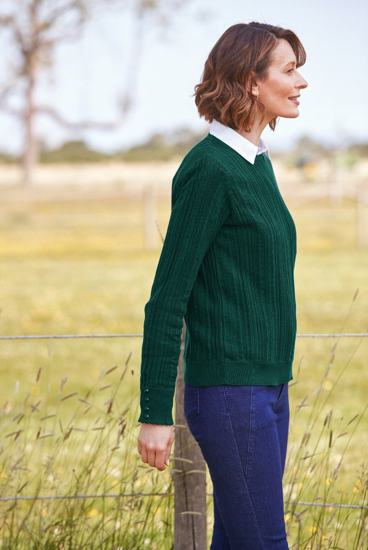 Lily Ella Collection green knit sweater, chic ribbed design, comfortable fall fashion, outdoor casual style, paired with blue trousers, elegant field background.