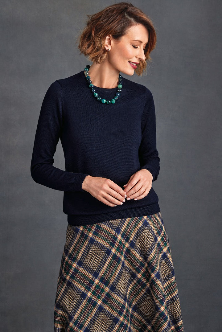 Lily Ella Collection navy blue textured sweater and plaid skirt, stylish women's fashion, elegant autumn-winter outfit, accessorized with a chunky teal necklace.