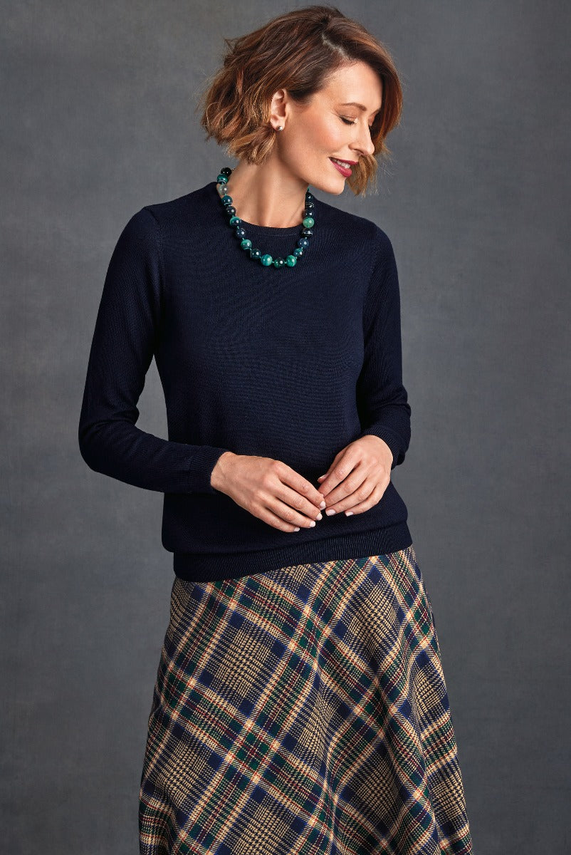Lily Ella Collection women's navy blue textured sweater paired with stylish plaid skirt, accessorized with bold turquoise necklace, elegant casual chic look.