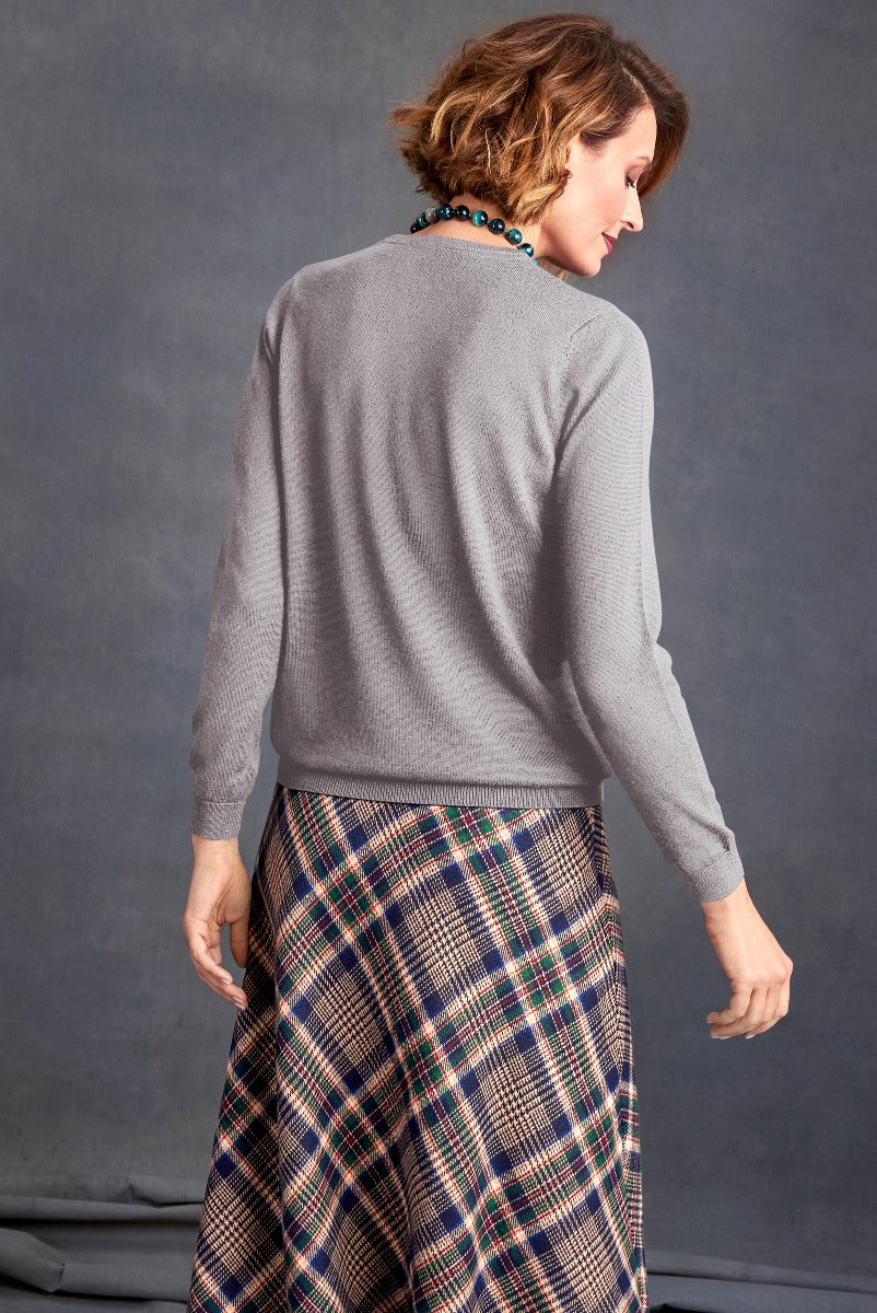 Lily Ella Collection grey cashmere-blend sweater paired with multicolor plaid skirt, elegant casual women's fashion, fall-winter attire, model showcasing back view of top with autumnal tones skirt