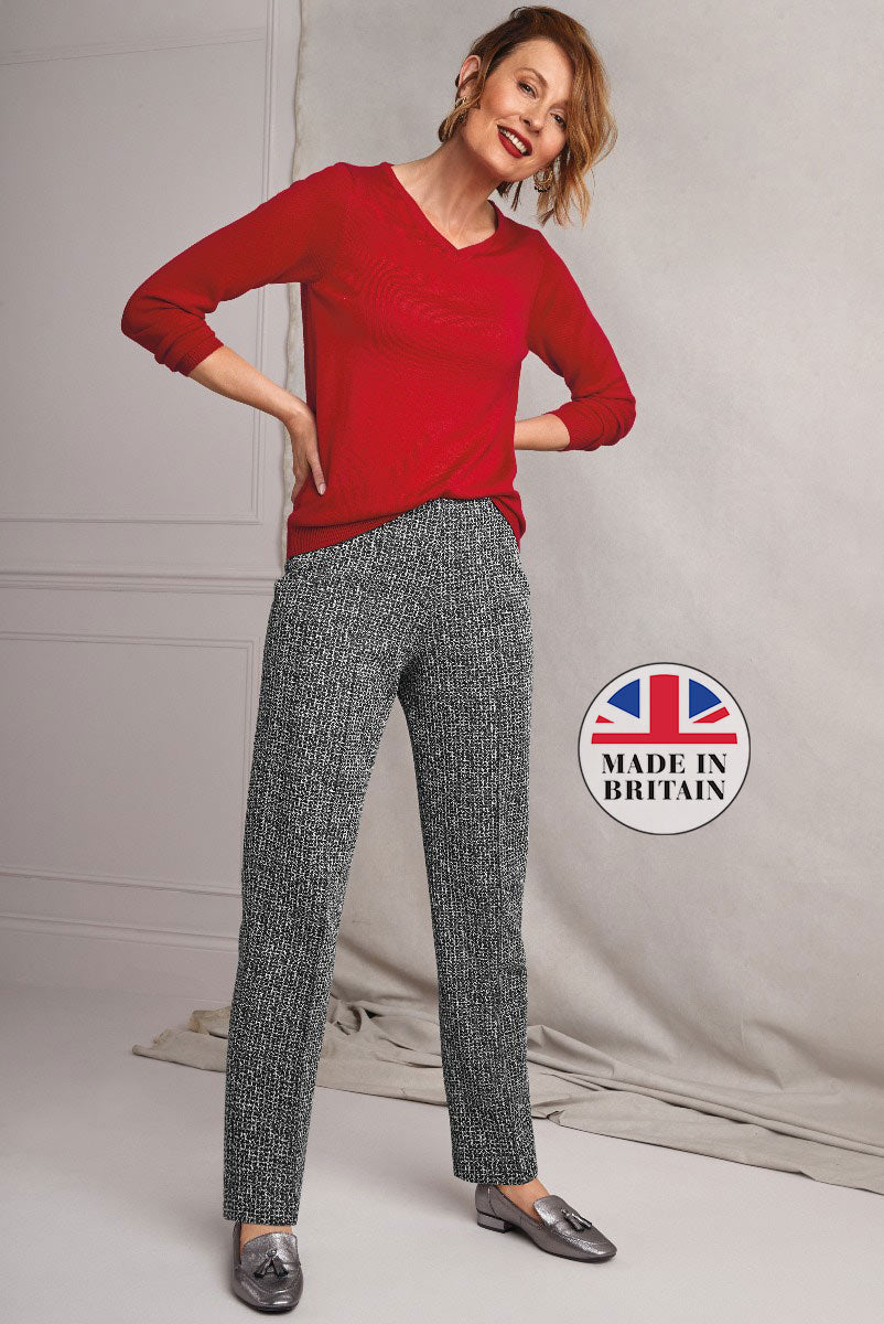 Lily Ella Collection stylish red sweater with unique pattern paired with classic tweed trousers for a sophisticated look, Made in Britain label visible, perfect for contemporary women's fashion.