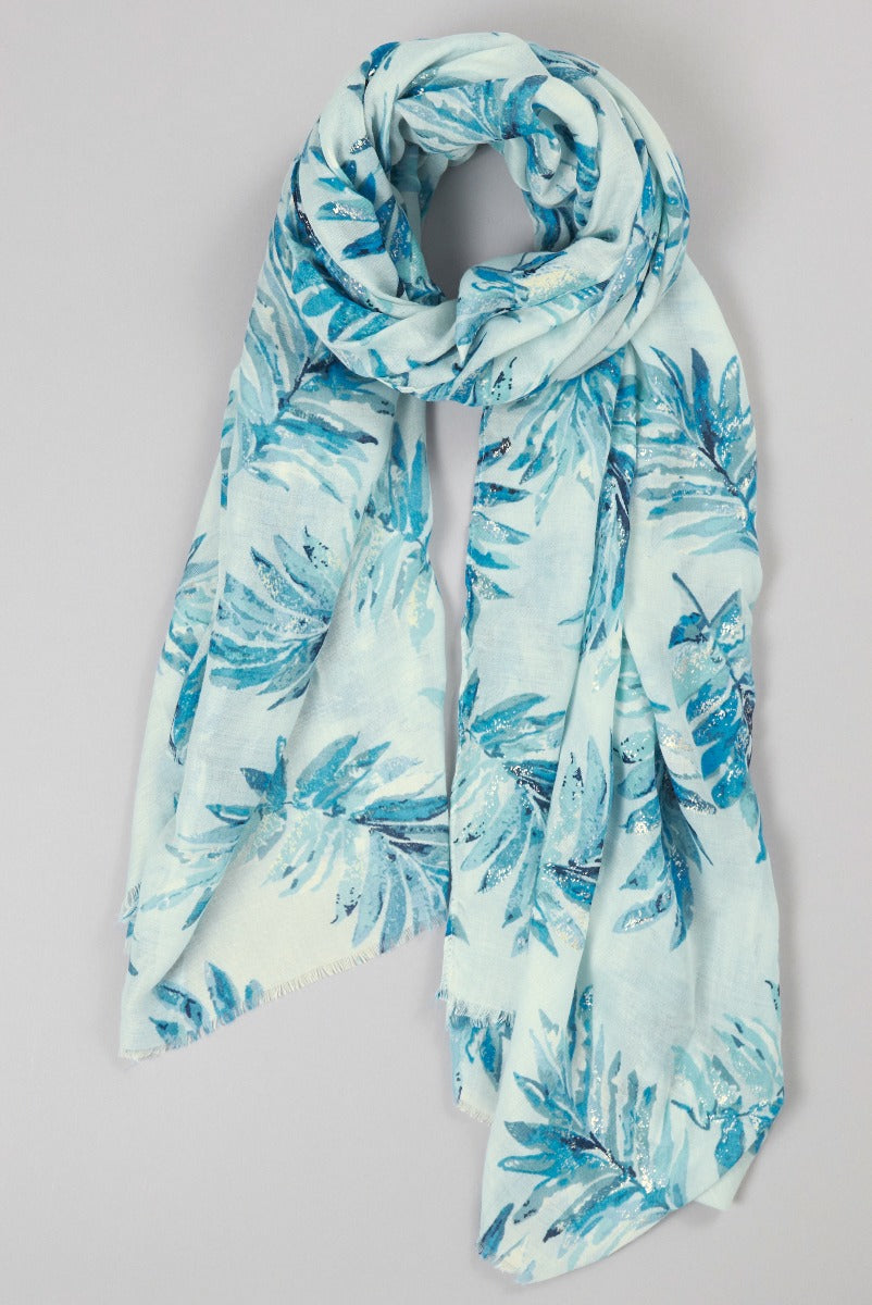 Lily Ella Collection light blue tropical leaf pattern scarf with subtle shimmer accents, stylish women's summer accessory.