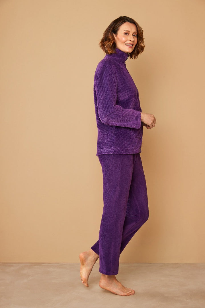 Lily Ella Collection purple textured loungewear set featuring high-neck jumper and comfortable trousers on smiling female model against neutral background.