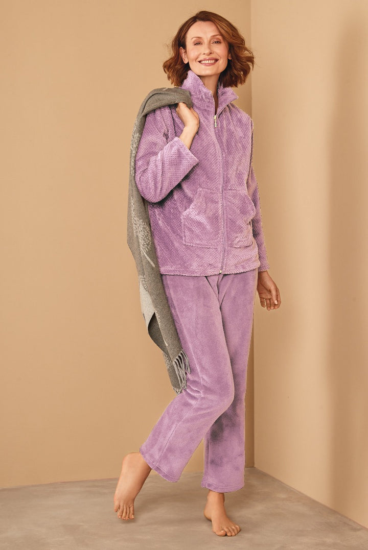 Lily Ella Collection lavender textured fleece zip-up jacket and matching lounge pants with model holding a grey fringed throw, showcasing comfortable chic women’s loungewear.