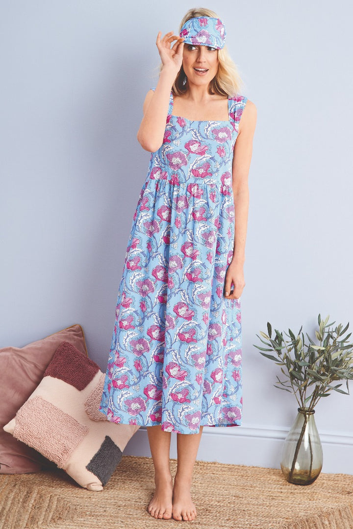 Lily Ella Collection blue floral tiered maxi dress with matching headband, woman posing in a stylish summer outfit against a neutral background with decorative elements.