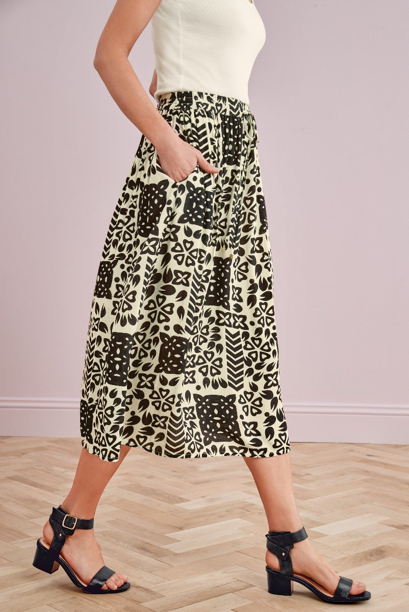 Lily Ella Collection beige and black patterned midi skirt, women's fashion, stylish printed skirt, elegant casual wear, with white top and black heeled sandals