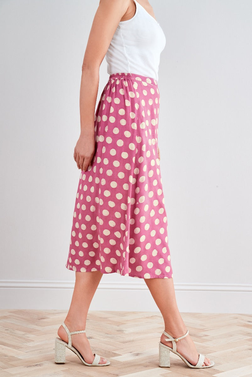 Lily Ella Collection pink polka dot midi skirt with white tank top and beige heeled sandals for women.
