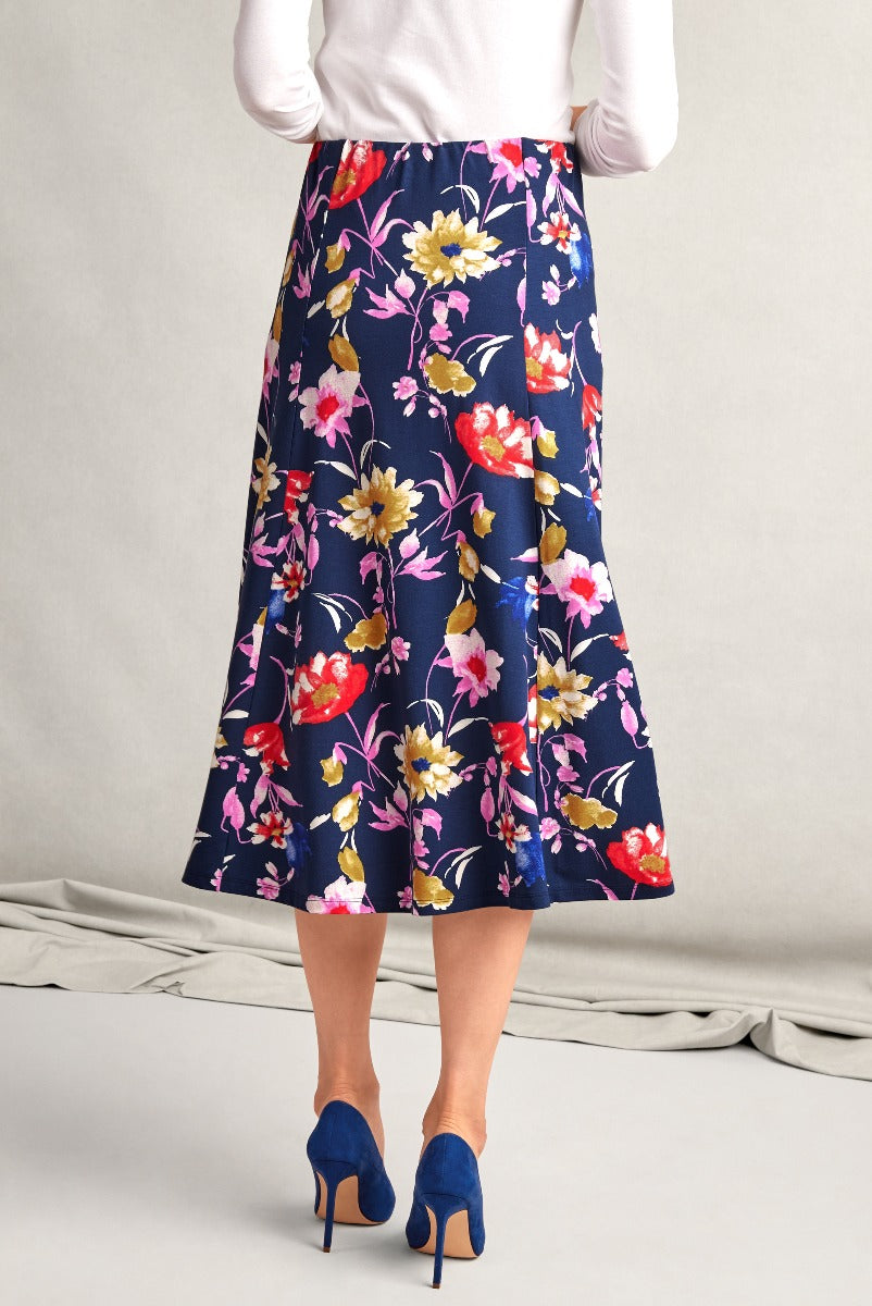 Lily Ella Collection floral A-line midi skirt in navy blue with pink and red blossom print paired with white top and blue high heels