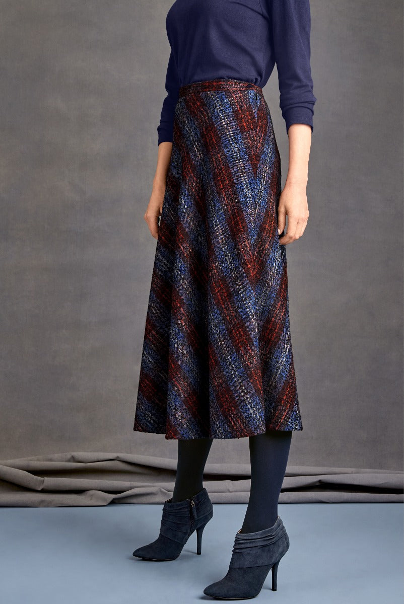 Lily Ella Collection women's fashion, navy blue long sleeve top paired with a stylish red and blue tweed mid-length skirt, complete with elegant navy blue ankle boots.