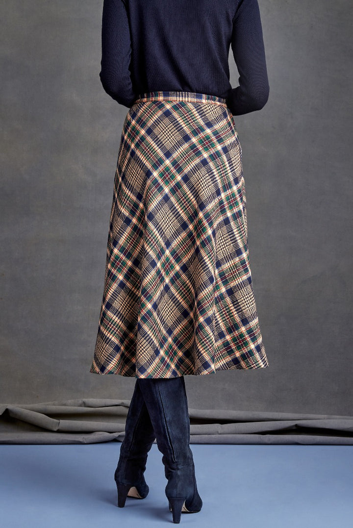 Lily Ella Collection tartan plaid midi skirt in beige with blue and green accents, paired with navy sweater and black knee-high boots, elegant women's apparel.