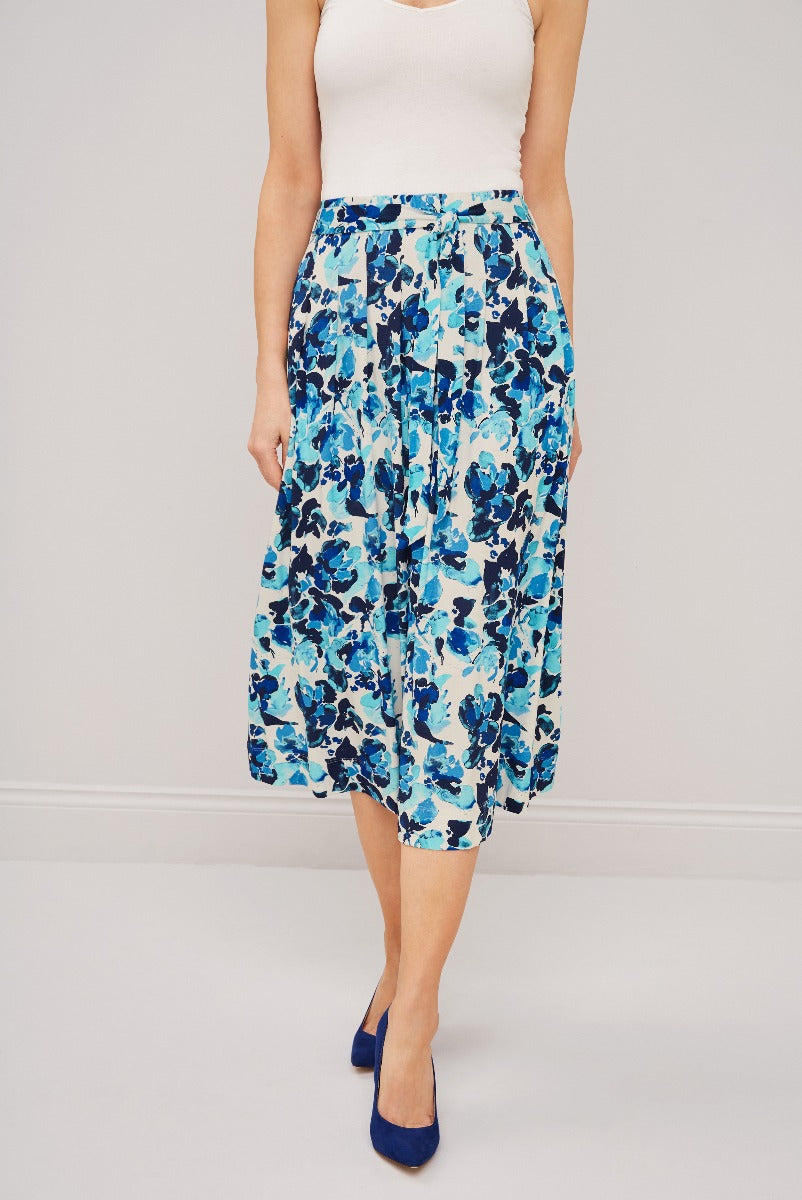 Lily Ella Collection blue floral midi skirt paired with a white tank top and navy heels for a stylish summer outfit