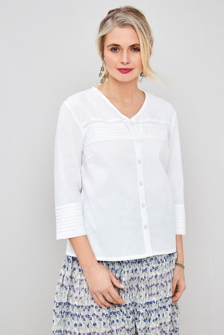 Lily Ella Collection white textured button-up shirt with three-quarter sleeves, styled with floral patterned skirt, fashion for women.