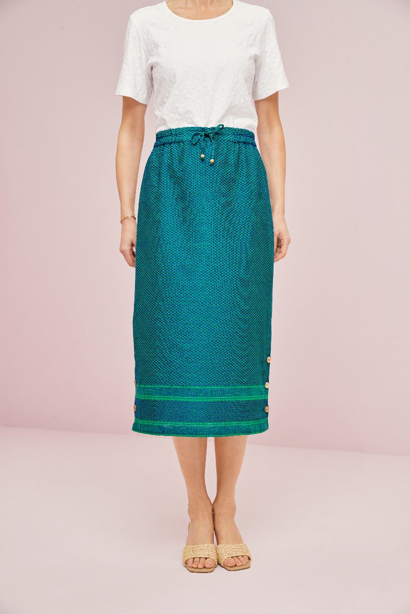 Lily Ella Collection women's teal mid-length skirt with drawstring waistband and button side details on pink background