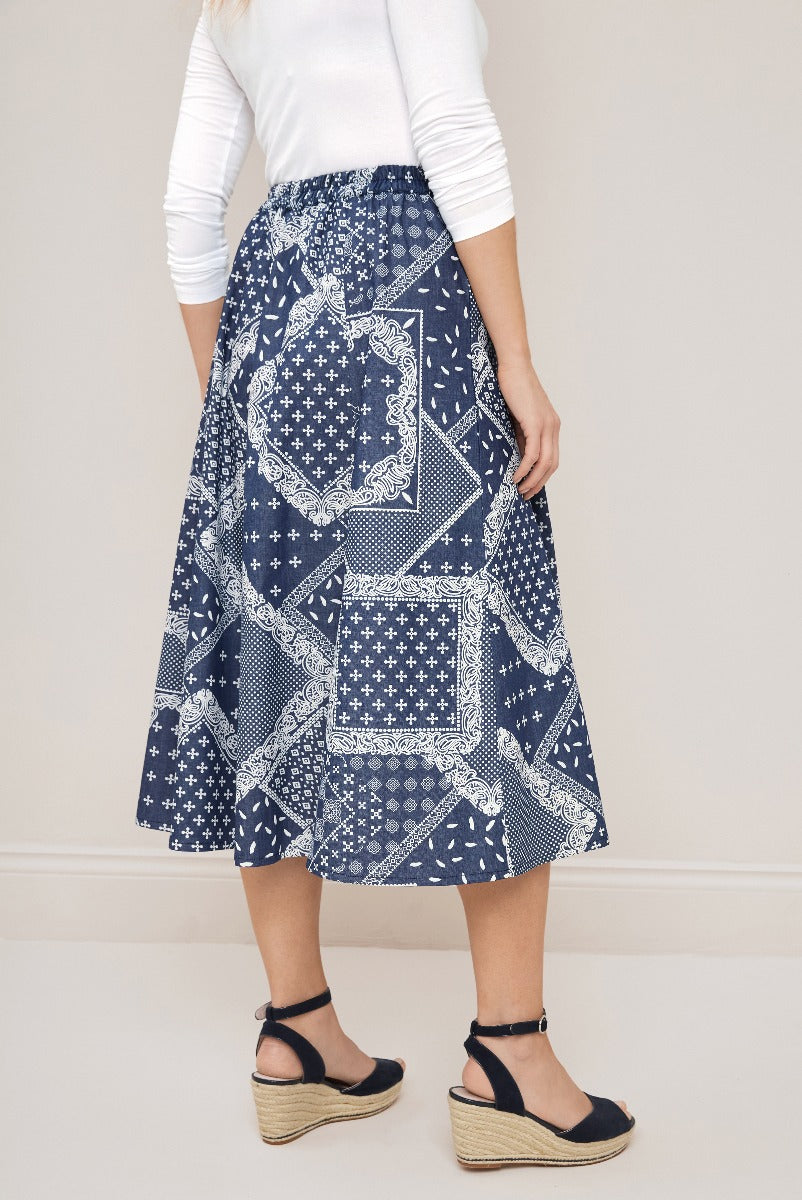 Lily Ella Collection blue and white patterned midi skirt with relaxed fit, white top and black wedge sandals for stylish women's fashion.