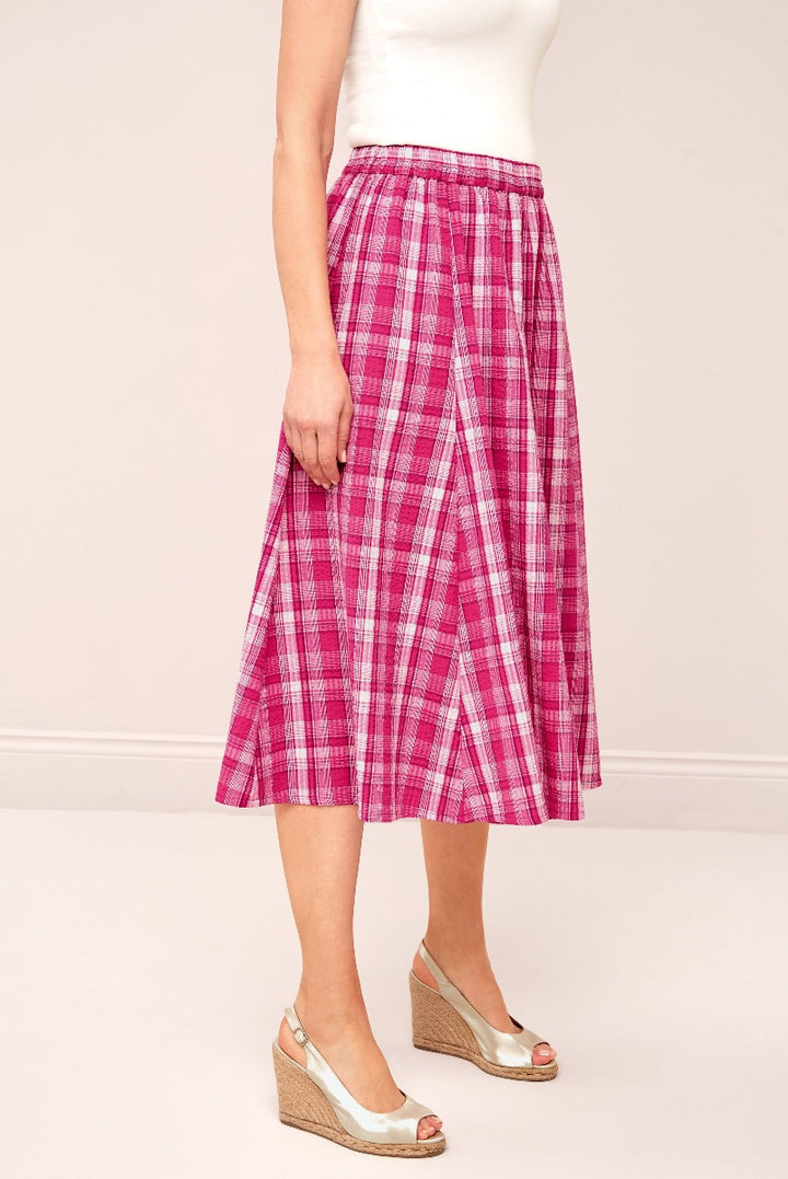 Lily Ella Collection pink plaid midi skirt paired with white top and beige wedge sandals, showcasing stylish women's summer fashion.