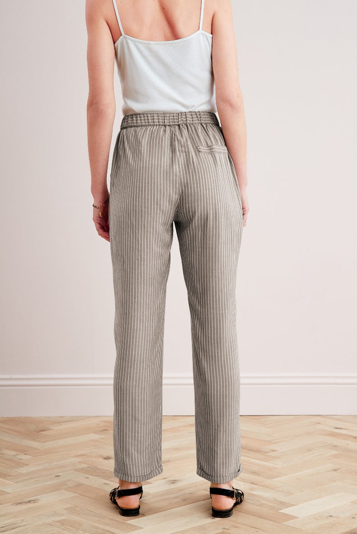 Lily Ella Collection elegant taupe striped women's high-waisted trousers with casual light blue tank top and black heeled sandals.