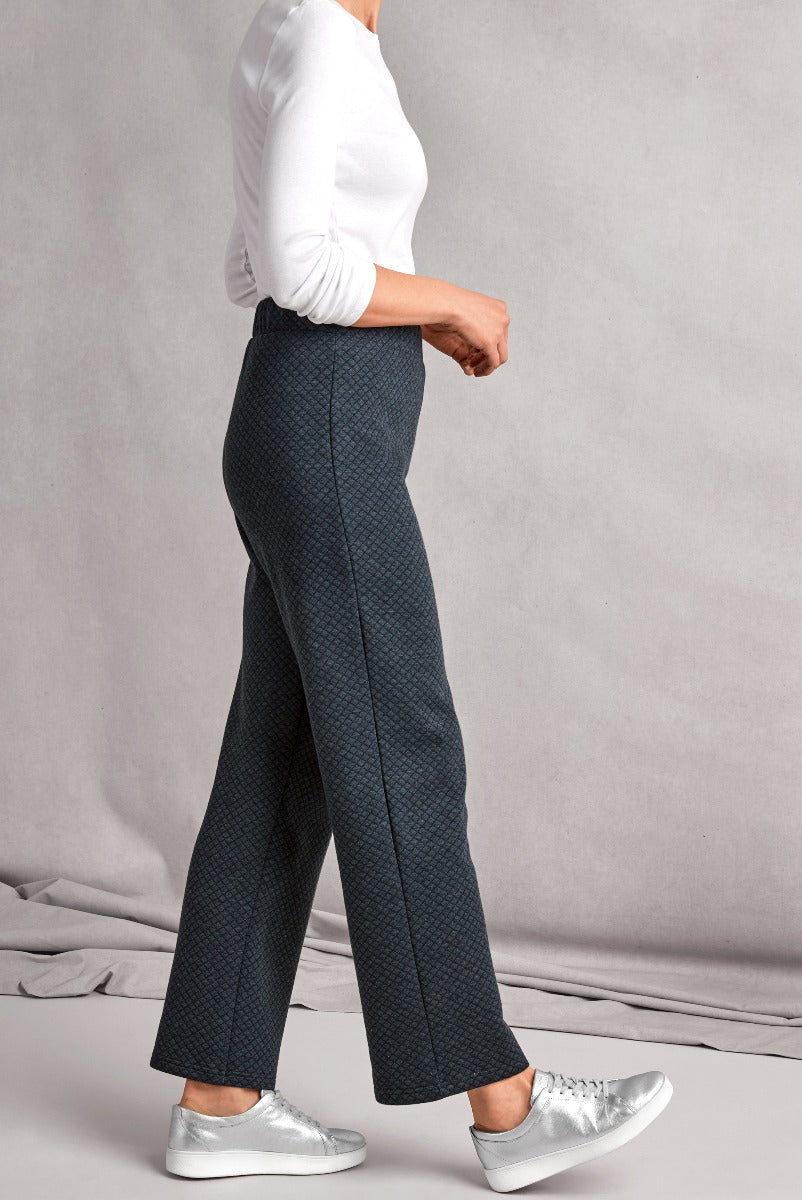 Lily Ella Collection navy patterned wide-leg trousers paired with a classic white top and silver sneakers, showcasing modern women's fashion style.