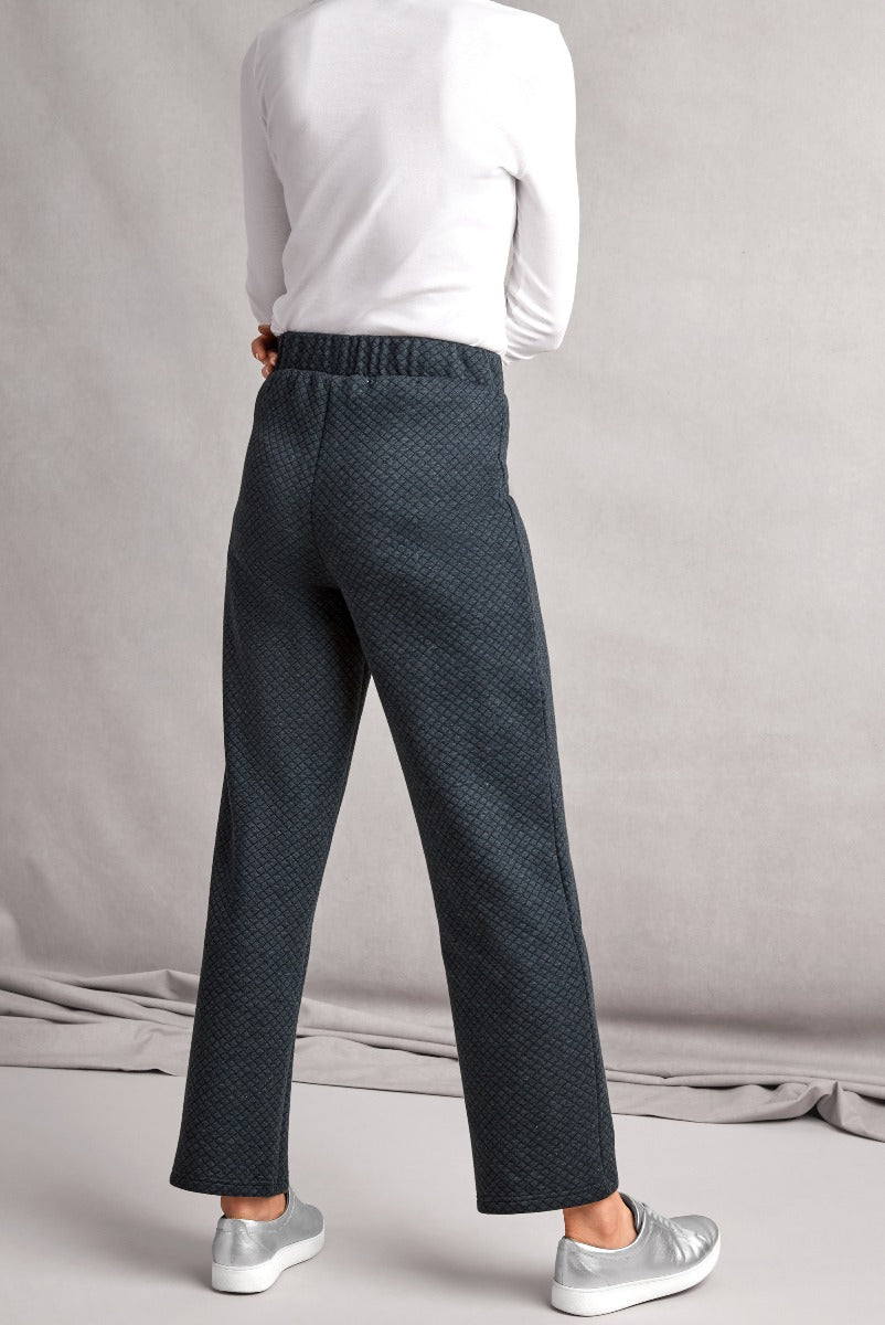 Lily Ella Collection women's navy patterned smart casual trousers, rear view showcasing elastic waistband and draped fit, paired with white top and silver sneakers.