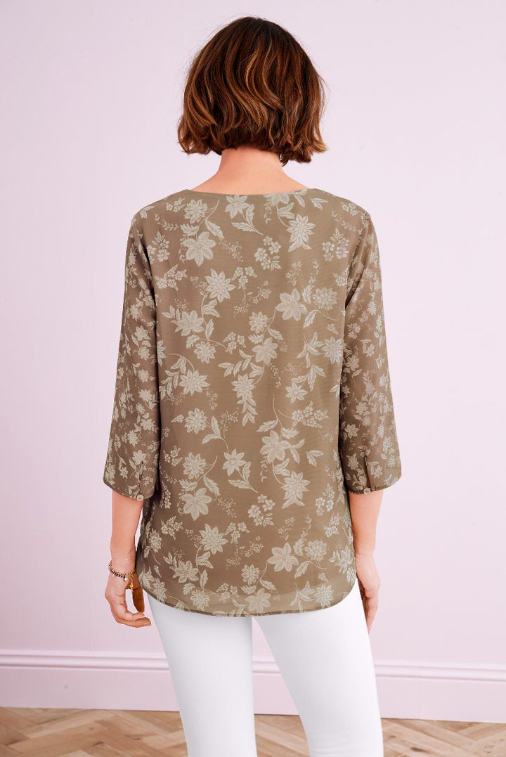 Lily Ella Collection taupe floral print blouse with three-quarter sleeves, styled with white trousers for a sophisticated women's fashion look.