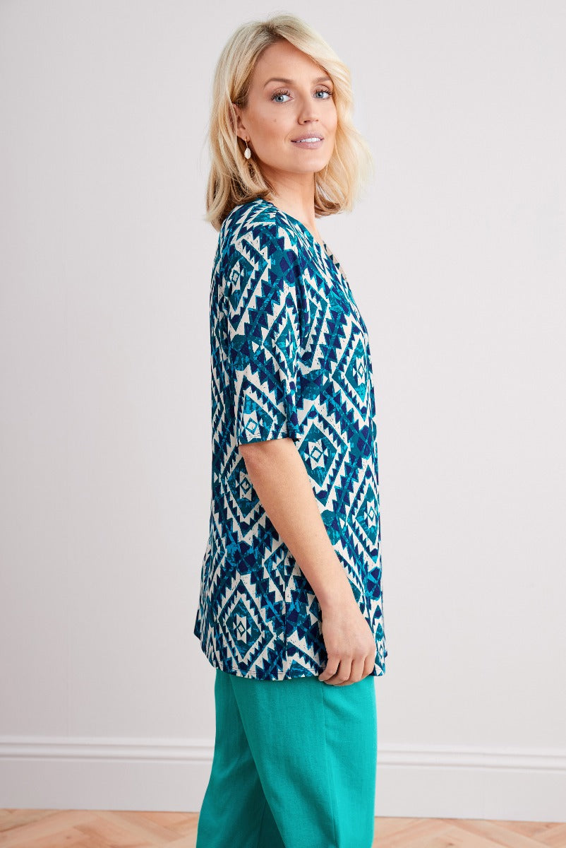 Lily Ella Collection vibrant teal geometric print tunic top with relaxed fit and coordinating turquoise trousers, stylish modern women's wear.