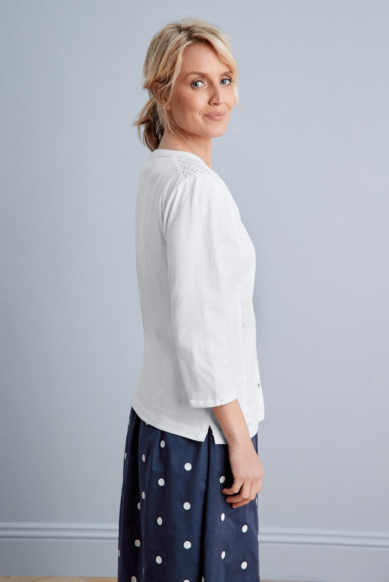 Lily Ella Collection white broderie anglaise blouse with three-quarter sleeves paired with navy polka dot skirt, stylish women’s spring-summer fashion.