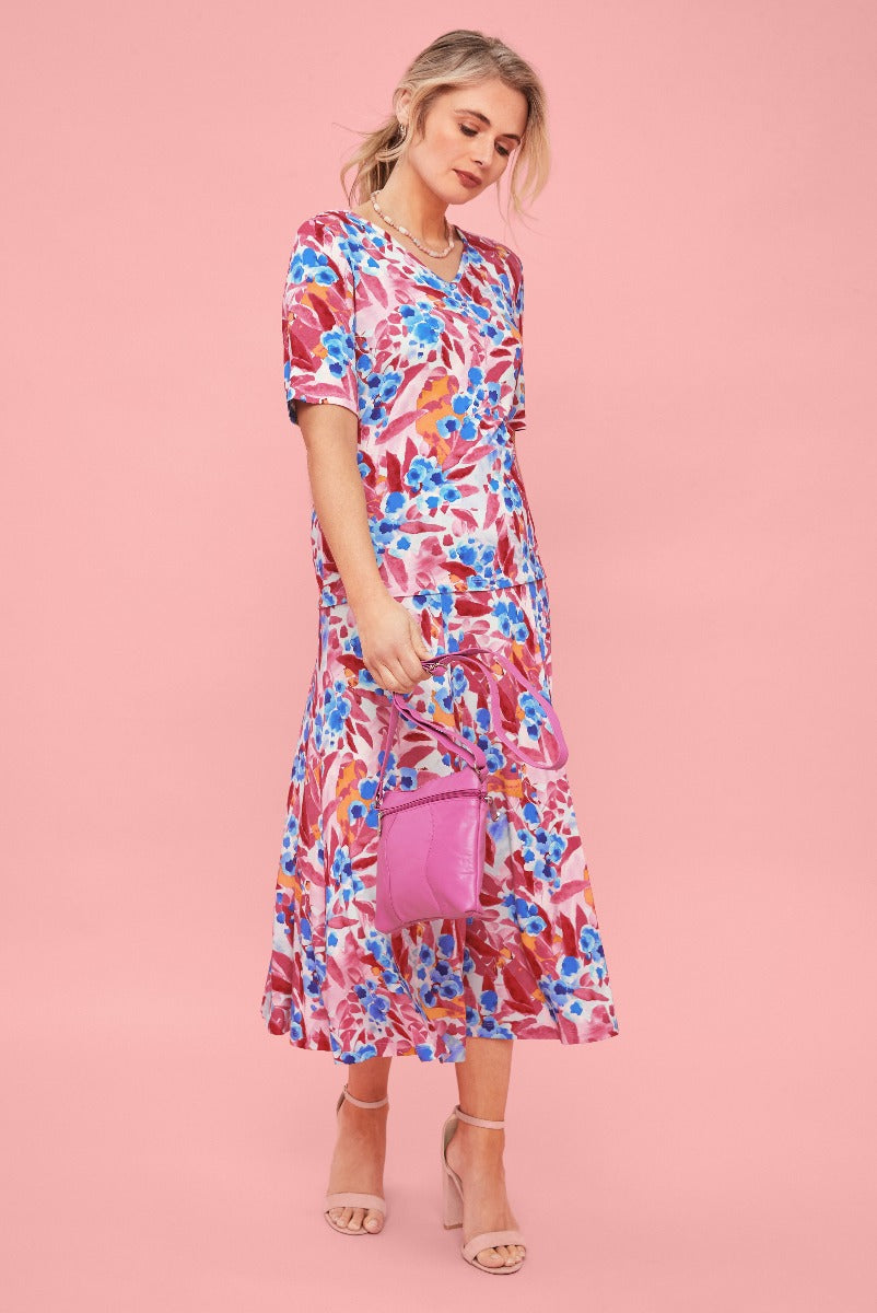 Lily Ella Collection floral midi dress in pink and blue, stylish women's summer fashion, accessorized with a pink crossbody bag and beige strappy heels.