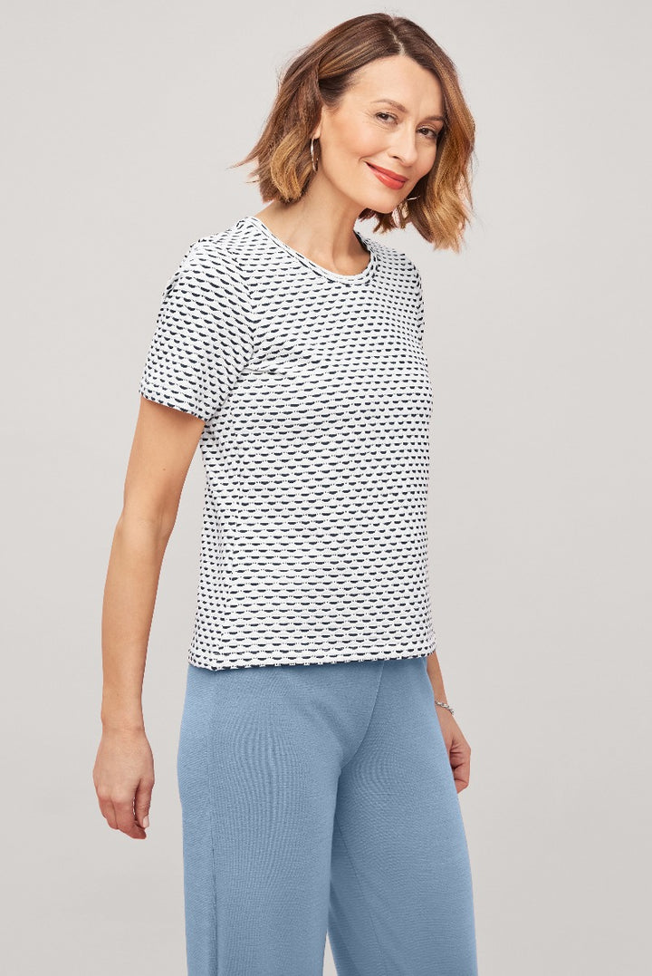 Lily Ella Collection black and white patterned top paired with blue trousers, featuring a stylish woman modeling contemporary casual wear