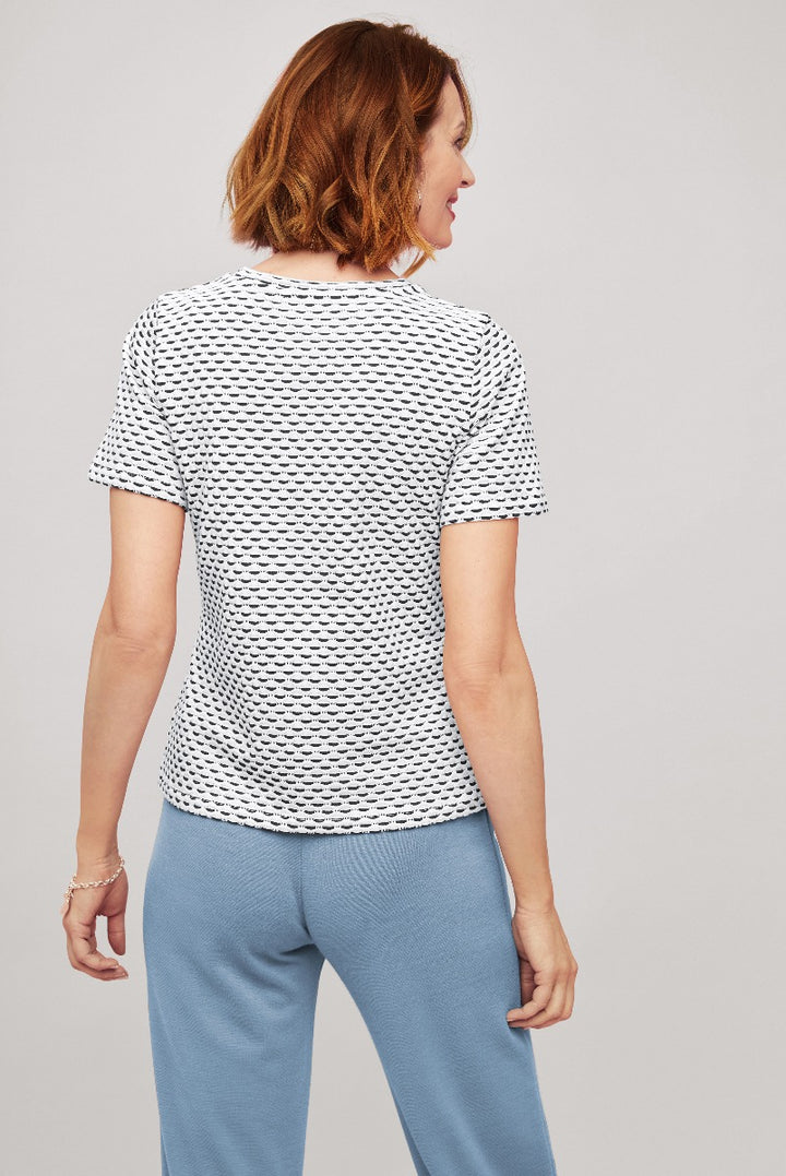 Lily Ella Collection black and white patterned short-sleeve top paired with light blue trousers, rear view of elegant casual women's fashion clothing.